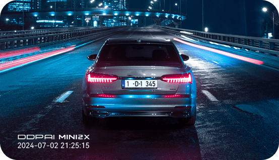 Clear night-time footage of a car on a brightly lit road captured by DDPAI MINI2X dashcam using NightVIS 2.0 technology.