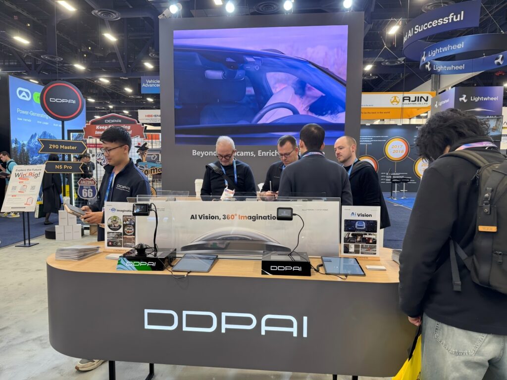 DDPAI booth at CES showcasing AI vision dash cam solutions, with live product demonstrations and visitor engagement